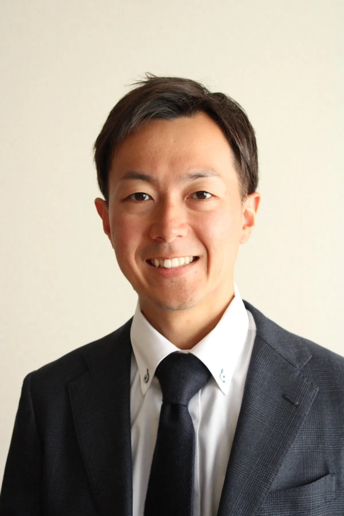 Manabu Kawahara, founder and owner of Camino Japan Travel, smiling in a dark suit.